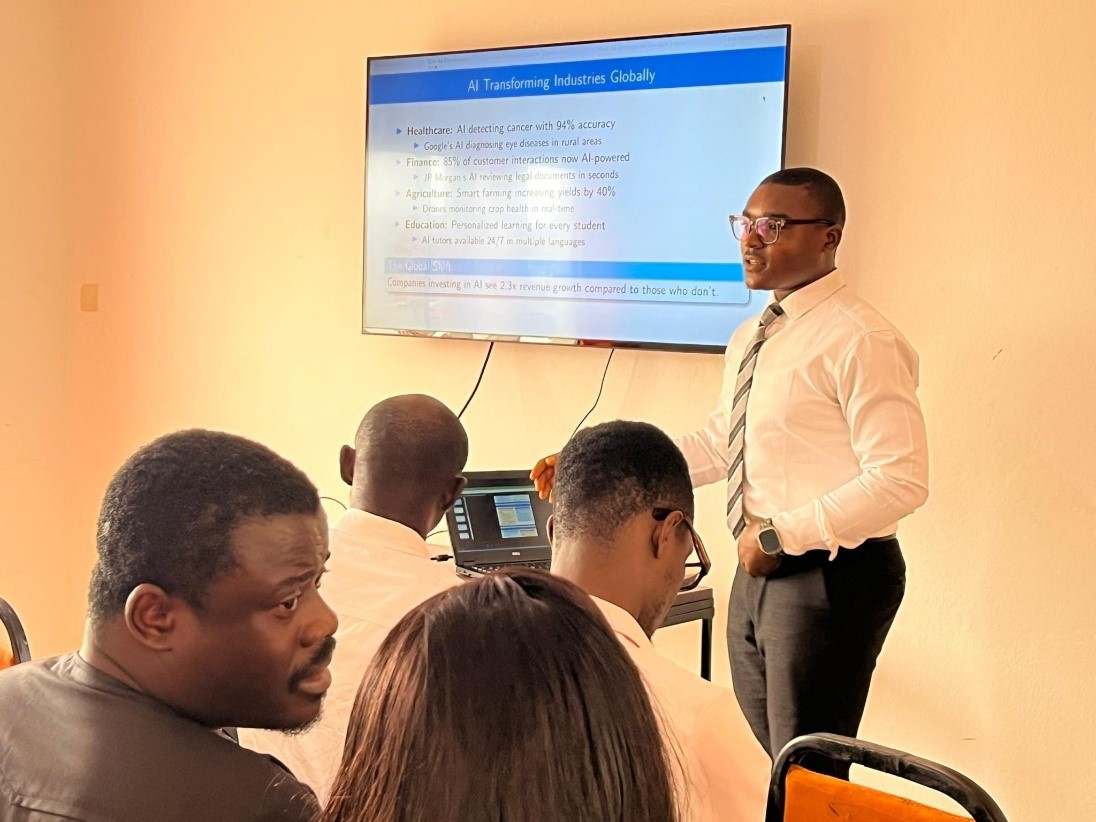 A diverse group of entrepreneurs, Impact Hub Phnom Penh staff members, and local farmers stand together smiling in front of a modern greenhouse structure in rural Cambodia, showcasing collaboration and partnership in agricultural innovation.